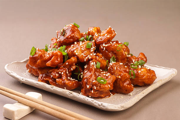 Crispy Korean fried chicken is a popular Korean dish, the chicken is coated in a light, flavorful batter and glazed with a savory-sweet sauce made from gochujang, garlic, soy sauce, and honey, garnished with sesame seeds and scallions.