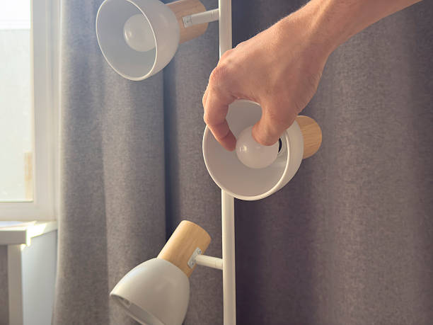 istock Changing a light bulb in a modern floor lamp at home during daytime 2252912001