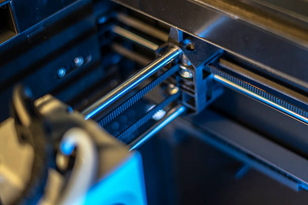 istock Close-up view of a 3D printer's mechanism, highlighting the belt system actively engaging while printing. This setup is situated in a contemporary workshop environment. 2252914607
