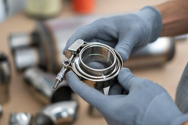 istock Mechanic holds a v-band exhaust component with focus on details, while preparing for assembly in an automotive repair workshop setting. 2252914781