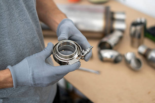 istock Mechanic holds a v-band exhaust component with focus on details, while preparing for assembly in an automotive repair workshop setting. 2252914784