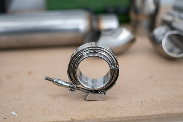istock An intricate v-band car exhaust component rests on a wooden table in a workshop, surrounded by shimmering metallic parts 2252914789