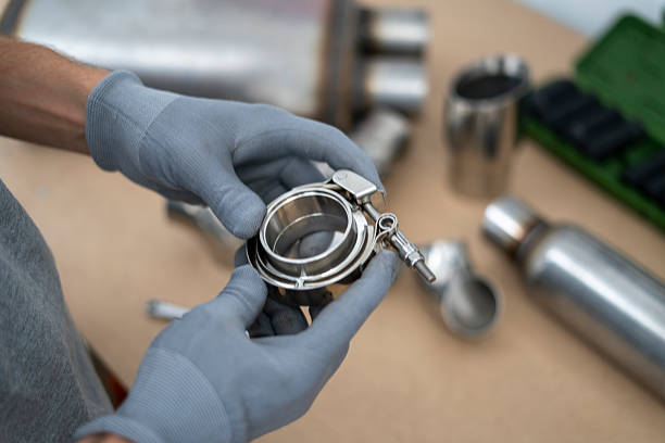 istock Mechanic holds a v-band exhaust component with focus on details, while preparing for assembly in an automotive repair workshop setting. 2252914790