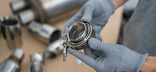 istock Mechanic holds a v-band exhaust component with focus on details, while preparing for assembly in an automotive repair workshop setting. 2252916728
