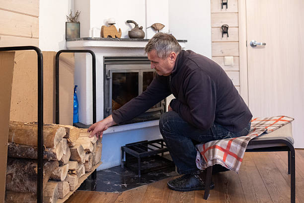 istock Senior man loading firewood into home fireplace indoors 2252925482