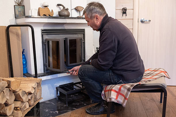 istock Senior man loading firewood into home fireplace indoors 2252925531
