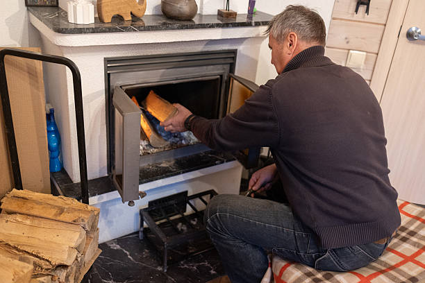 istock Senior man loading firewood into home fireplace indoors 2252925571