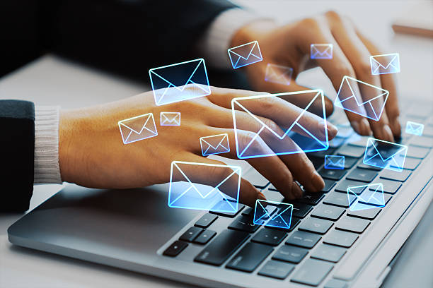 istock Hands typing on laptop keyboard with glowing email icons floating above, representing digital communication and online messaging concept. 2252925865