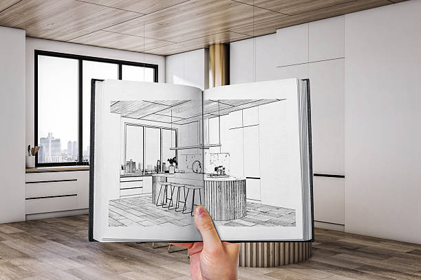 istock Hand holding interior design sketch book with modern kitchen drawing aligned to real room background, showing light wood and white concept match. 2252925998