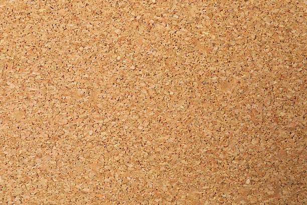 A close-up view of a corkboard surface showing tightly packed cork particles, commonly used for pinning notes or announcements.