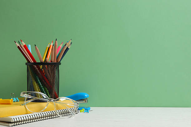 istock Colorful and modern workspace with pencil holder, notebooks and green wall 2252927539
