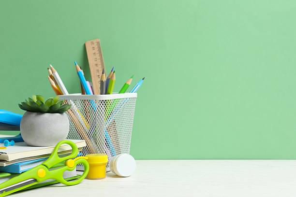istock Colorful and modern workspace with pencil holder, notebooks and green wall 2252927559