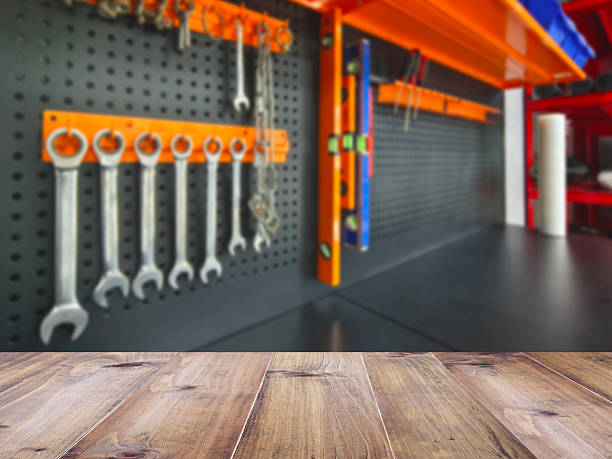 Wooden table top over blurry background of power tools on shelf display background at hardwear store or factory.