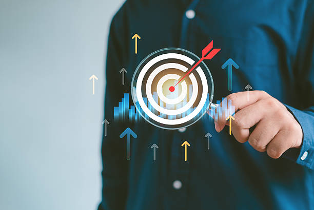 istock Businessman holding a magnifying glass over a digital target with upward arrows, representing business growth, marketing analysis, KPI tracking, investment strategy, and data-driven success. 2252928053