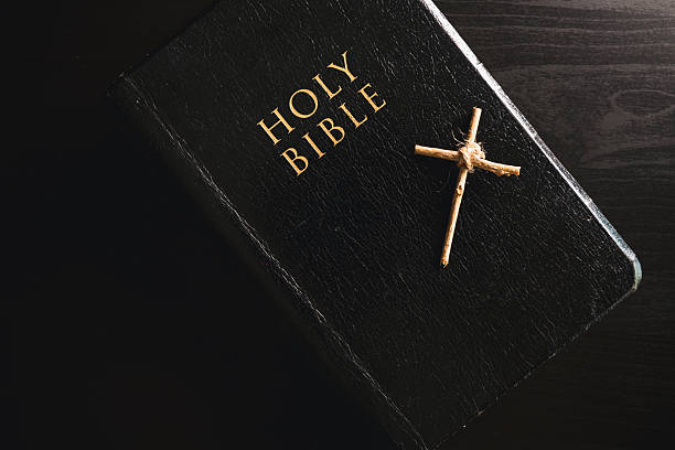 istock Holy Bible small wooden cross placed black leather cover dark dramatic light symbolizing Christian faith belief worship devotion religion background copy space for church prayer spiritual concept 2252928224