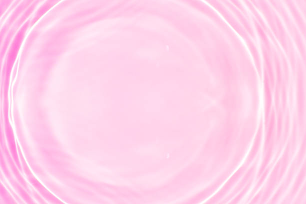 istock Pink water bubbles on the surface ripples. Defocus blurred transparent pink colored clear calm water surface texture with splash and bubbles. Water waves with shining pattern texture background 2252928403
