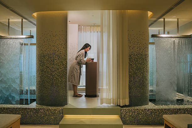 istock Asian female smelling essential oil diffuser before spa thermal pool ritual 2252928422