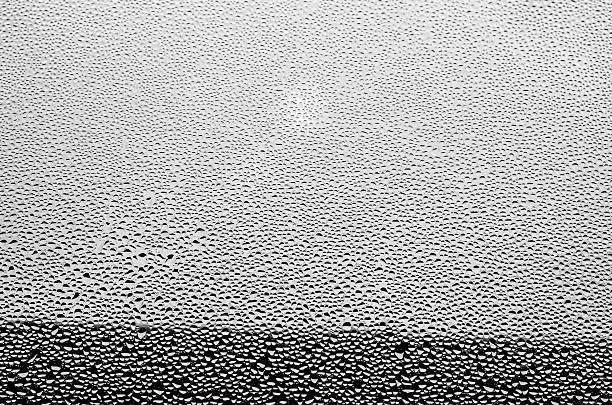 Water drops on glass like tears creating dramatic black and white background