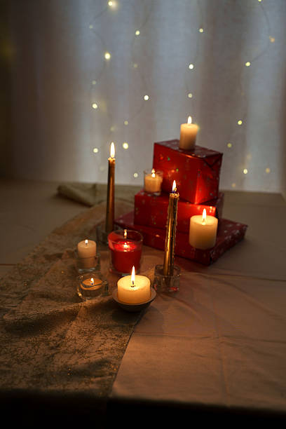 istock cozy candlelit scene with softly glowing lights and red gift boxes on elegant tablecloth exuding christmas warmth and tranquil holiday atmosphere, twinkle, festivity, comfort, happy, golden 2252937773