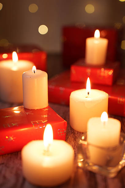 istock warm candlelit scene featuring glowing candles amidst red gift boxes, capturing a festive atmosphere with soft bokeh highlights and subtle wood texture in a cozy setting, tender, radiant, blissful 2252937984