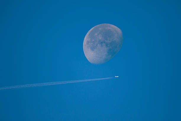 istock Airplane Flying Beneath the Moon in a Clear Sky 2252938246