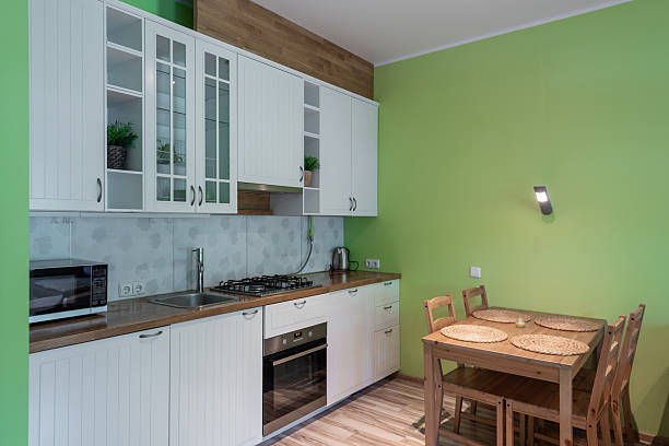 istock Modern Kitchen Interior with Green Walls and Wooden Dining Table 2252939079