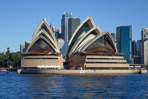Sydney, NSW, Australia. June 28, 2015. - The world-famous Sydney Opera House stands prominently on the waterfront, backed by the city's modern high-rise skyline.