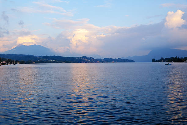 Panoramic view of Lake Lucerne at twilight, distant mountains with sunset clouds