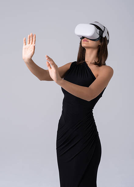 istock Woman exploring virtual reality with VR headset, wearing elegant 2252942195