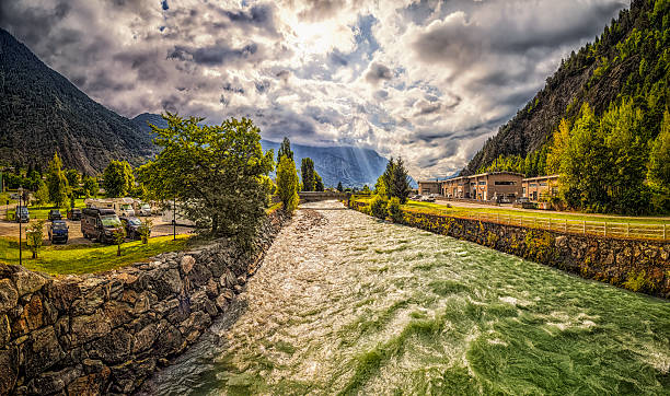Mountain valley Fiume Dora Baltea (river) flowing by campsite an