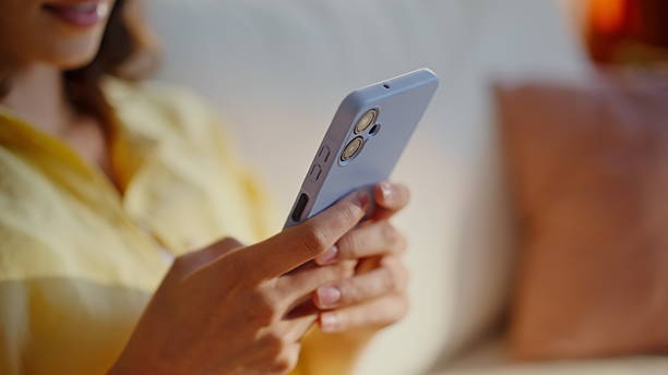 istock Closeup hands typing mobile phone apartment sofa. Young woman texting message 2252943114