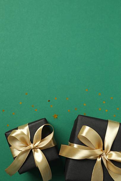 istock Beautiful gift boxes tied with golden bows on color background 2252945396