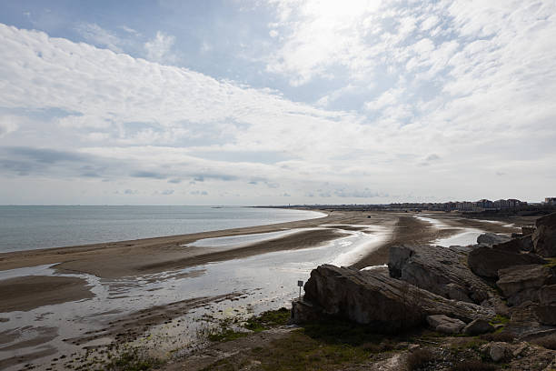 istock A tranquil seaside landscape features a long sandy shore, calm water and rocks 2252946124