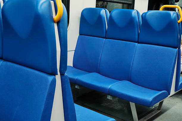 istock Blue vinyl seats in row, with yellow grab handle, inside an empty public transportation coach 2252947094