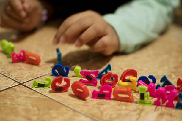 istock Child Playing with Colorful Magnetic Alphabet Letters 2252949114