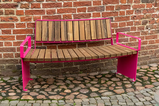 istock Pink modern bench sitting against old brick wall 2252952340