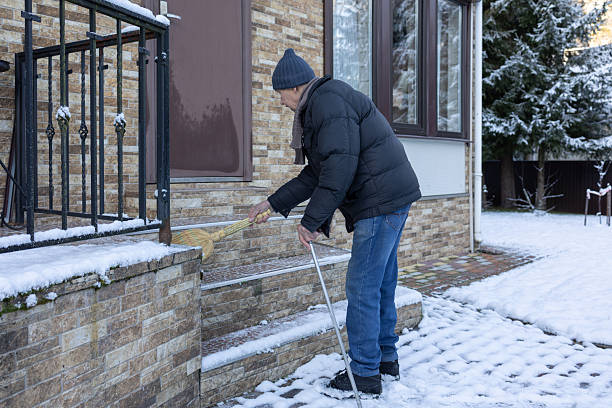 istock Man Sweeping Snowy Porch in Winter 2252954510