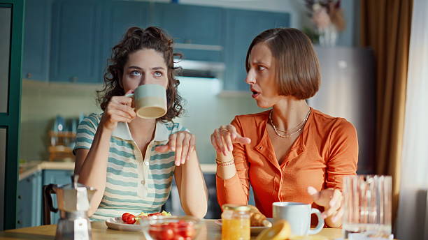 istock Relaxed besties drinking tea at morning kitchen closeup. Smiling two friends 2252954634