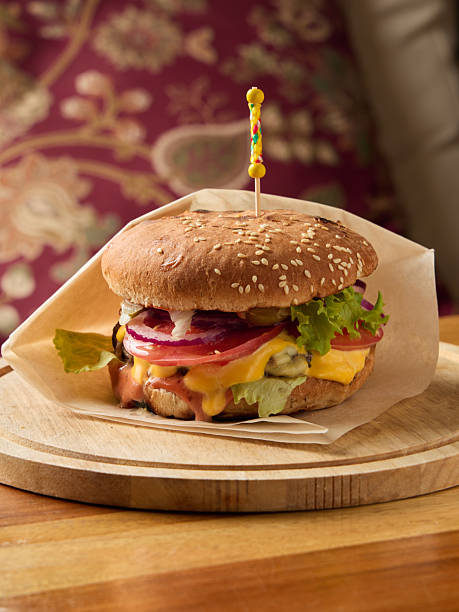 istock Grilled cheese burger with crisp vegetables, Delicious melted cheese burger with sesame bun and toppings 2252957162