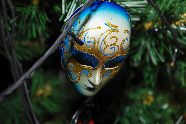 Carnival venetian mask with golden stars confetti on deep red background close up. Luxury masquerade mask. Purim party template.