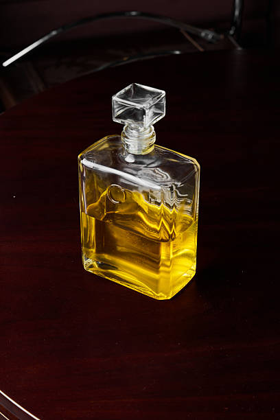 Amber Glass Bottle On Mahogany Table, Moody Still Life With Warm Highlights, Vintage Stopper And Deep