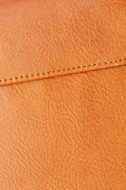 istock Orange leather surface macro,Brown macro synthetic leather,Synthetic leather brown background texture. Brown leather textured background. 2252959636