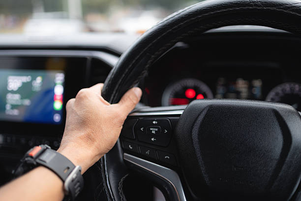 istock Human hands holding a car steering wheel,A man holding the steering while driving an expensive car. Man hand close up at the car interior 2252960099