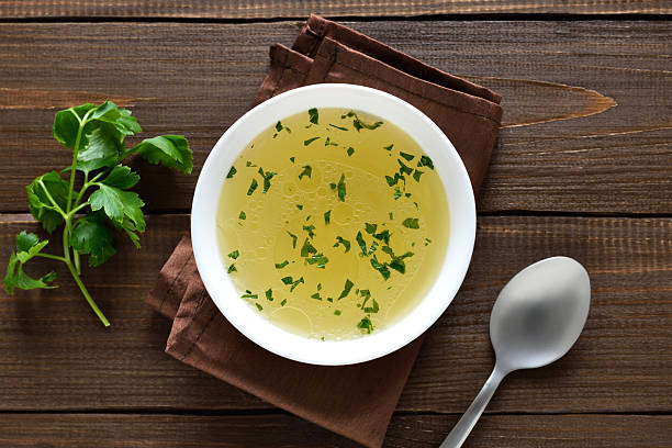 istock Chicken broth in bowl over wooden background 2252964121