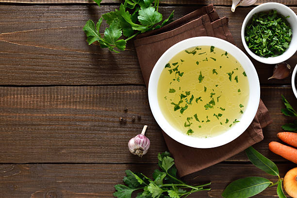istock Chicken broth in bowl over wooden background 2252964205