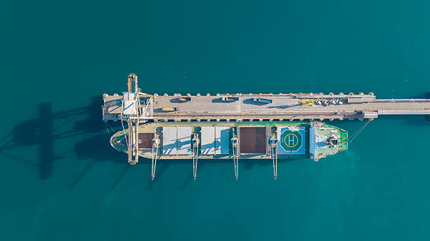 istock Aerial top view of a cargo ship docked at a port with loading cranes 2252964824