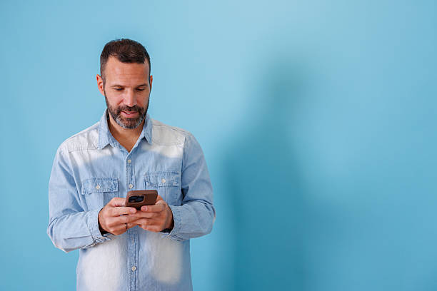 istock Man smiling while texting on smartphone, enjoying modern mobile communication and connection 2252965084