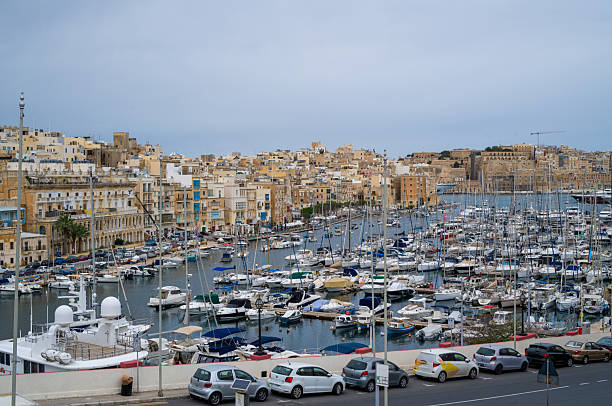 View of the Grand Harbour in Valletta, Malta. Numerous boats are docked, showcasing the city's maritime history and current yachting culture.