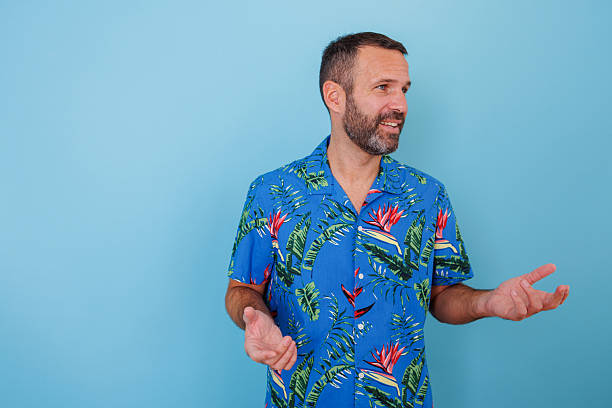 istock Man in a brightly colored tropical shirt making a point or asking a question while looking to the side 2252971034