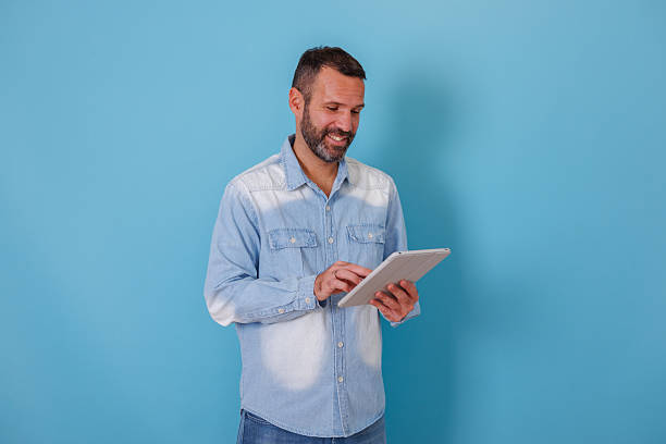 istock Happy man engaging with digital tablet, browsing social media, and enjoying online content 2252974617